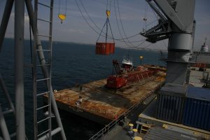 SS Cornhusker State using one of its cranes to load containers aboard the barge Atlantic Trader off the coast of Haiti, February 2010. Atlantic Trader was awarded a DOD contract for the operation as part of its enrollment in the VISA program. Photograph by John Spears, Maritime Administration.